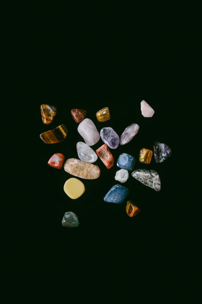 journey-01 A diverse collection of colorful minerals and gemstones on a dark studio backdrop.