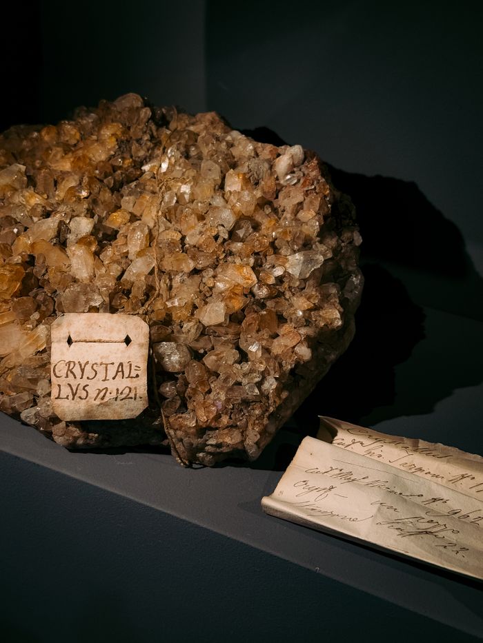 Close-up of a crystal mineral specimen accompanied by vintage handwritten labels.