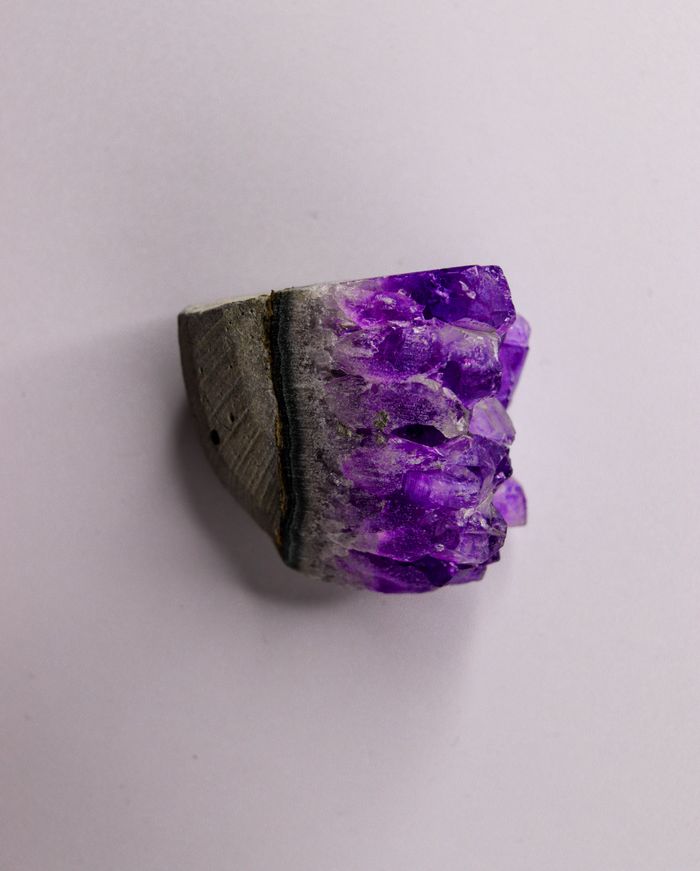 A detailed shot of a raw amethyst crystal showing its vibrant purple hues and natural texture.